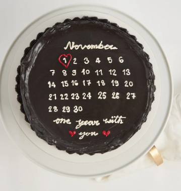 Black anniversary cake with November calendar and red heart around November 1
